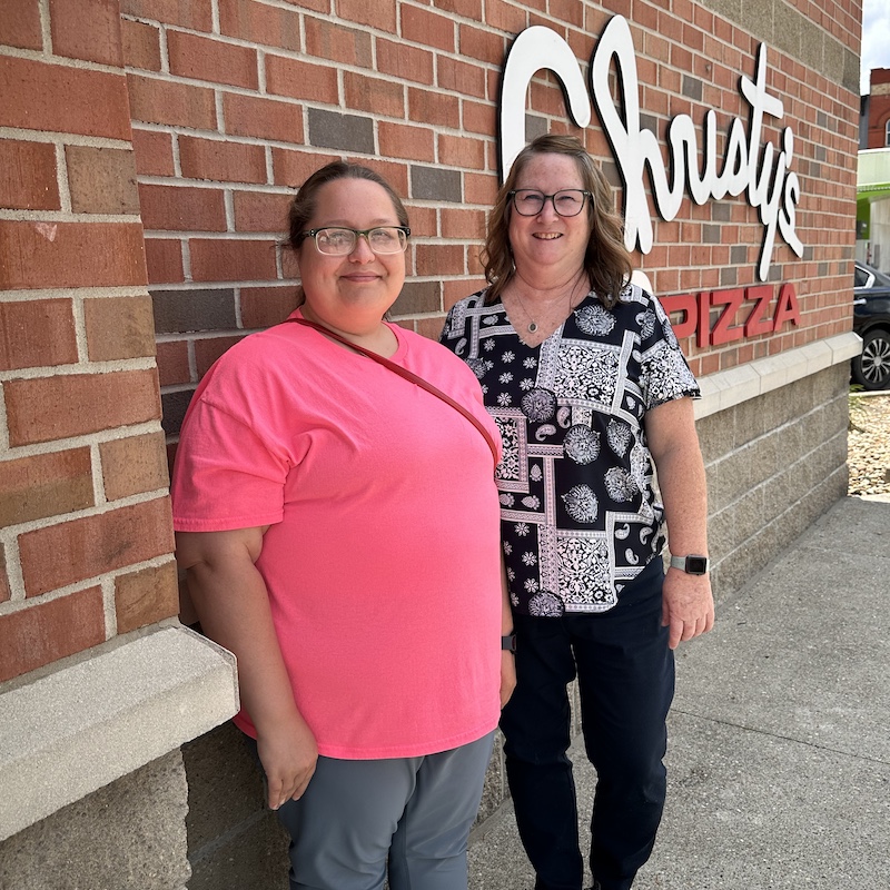 Jeanette and Brittany in front of a brick wall